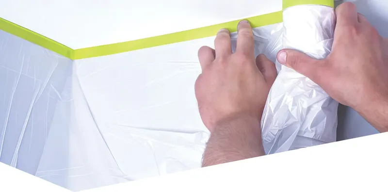 Плёнку SPEEDY MASK разворачивают от малярной ленты, наклеенной по стене